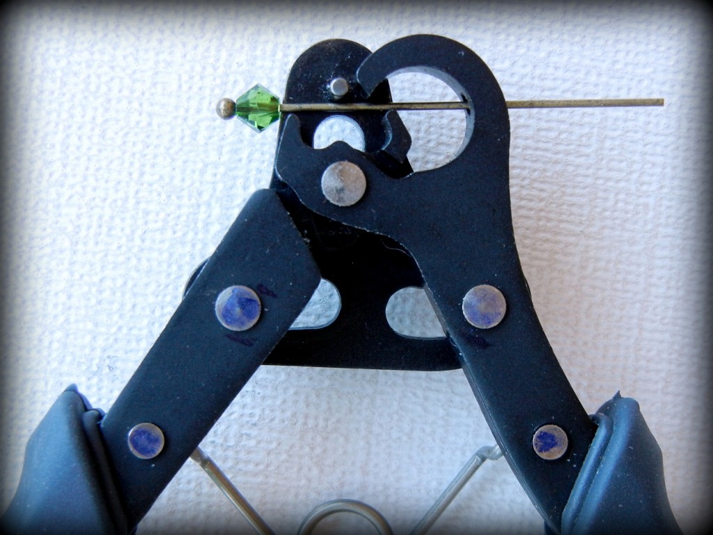 To use the 1-Step Looper start by inserting a beaded head pin in the pliers' jaw. 