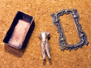Antique and patina the frozen charlotte doll, the ornate brass frame and the brass metal box to create the reliquary.