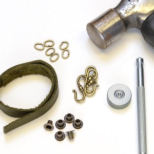 Gather the necessary supplies (leather strip, eyelets, locking jump ring, S clasp, eyelet setter, hammer, leather hole punch).