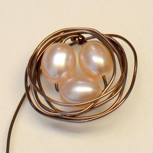 Step 5. Wrap the wire 5-6 times around the pearl beads.  (Add more wraps for a thicker nest.) Don't try to be too neat! This style of wire wrapping is supposed to be a bit messy.