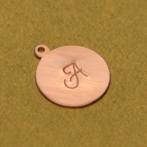 A successfully stamped metal blank charm.