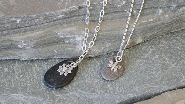 These lovely necklaces by Amy Mickelson combine rustic river rock and dainty sterling silver charms!